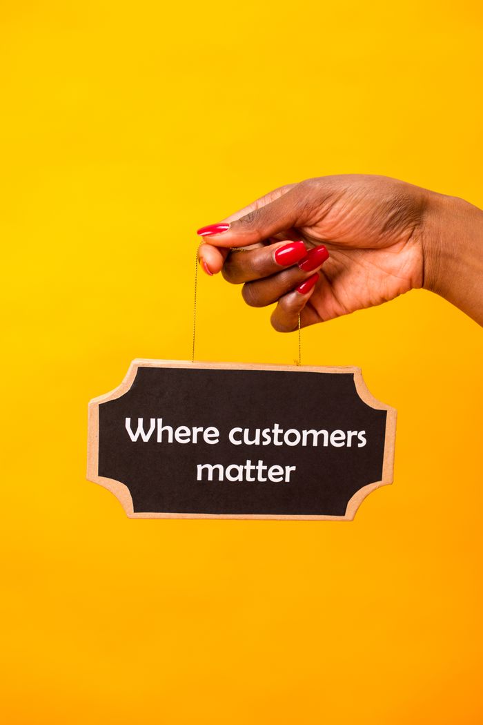 services-04 Hand holding a sign with 'Where customers matter' on a vibrant yellow backdrop.